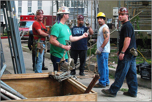 Restoration workers carefully repairing a section of Beroun’s city walls, tools in hand