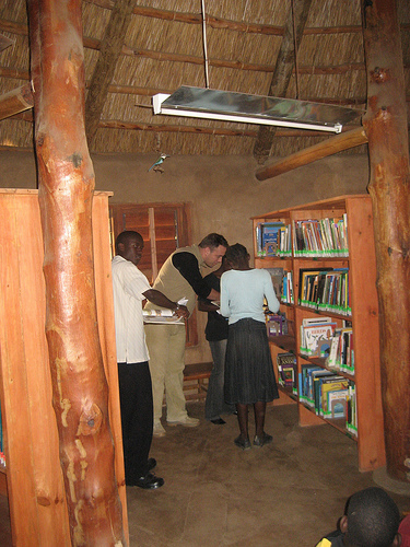 A collection of multilingual books on a wooden shelf